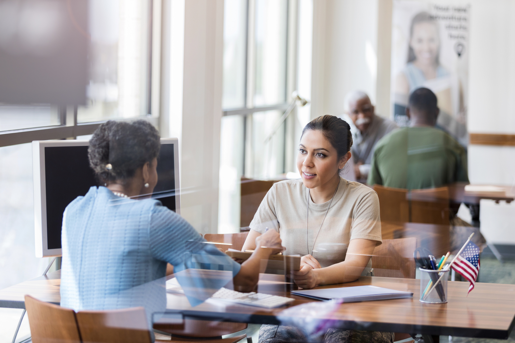 GettyImages-1149285452.jpg People shaking hands over a desk in a bank.