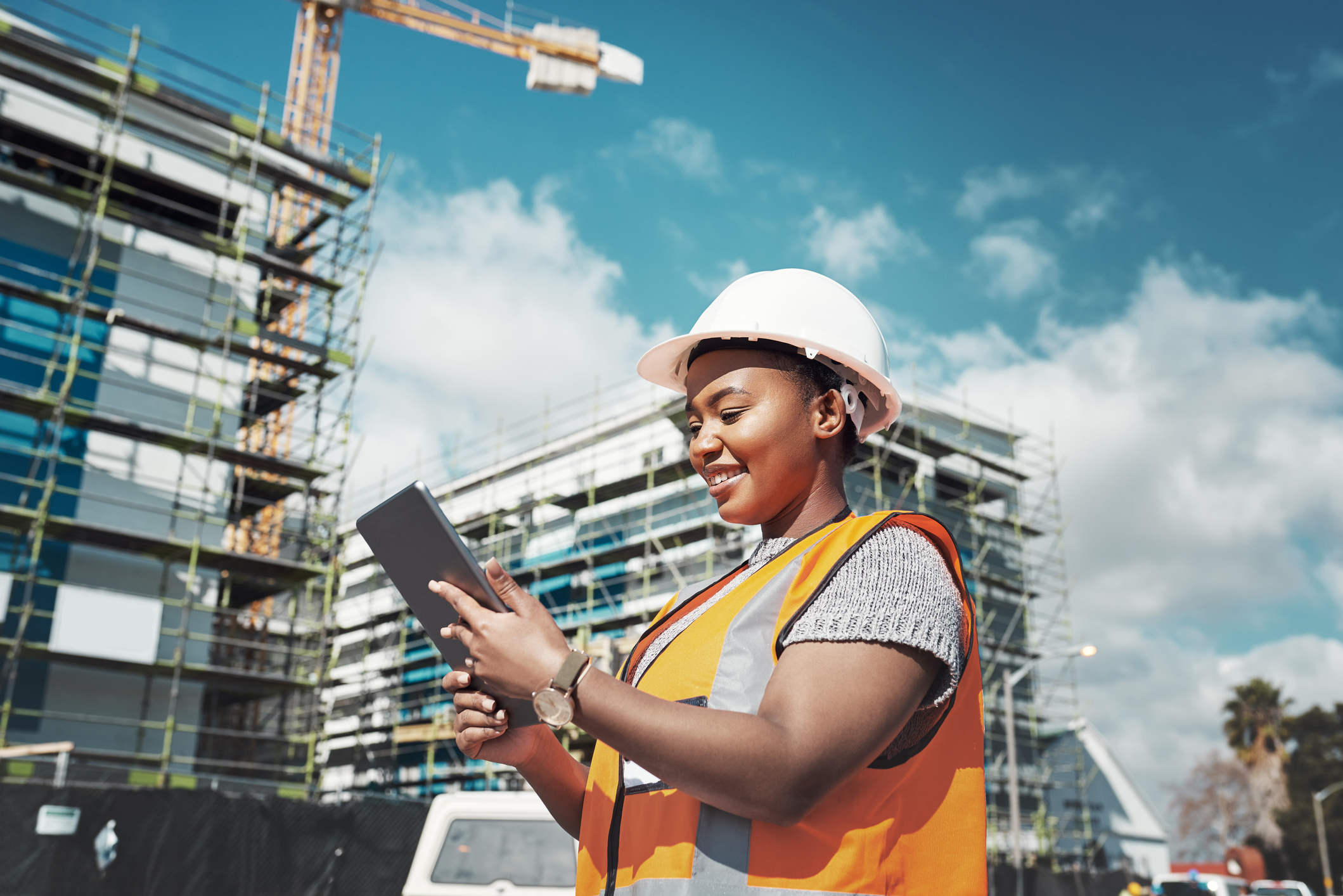 Smiling construction worker looking at tablet--GettyImages-1297780275.jpg Smiling construction worker looking at tablet.