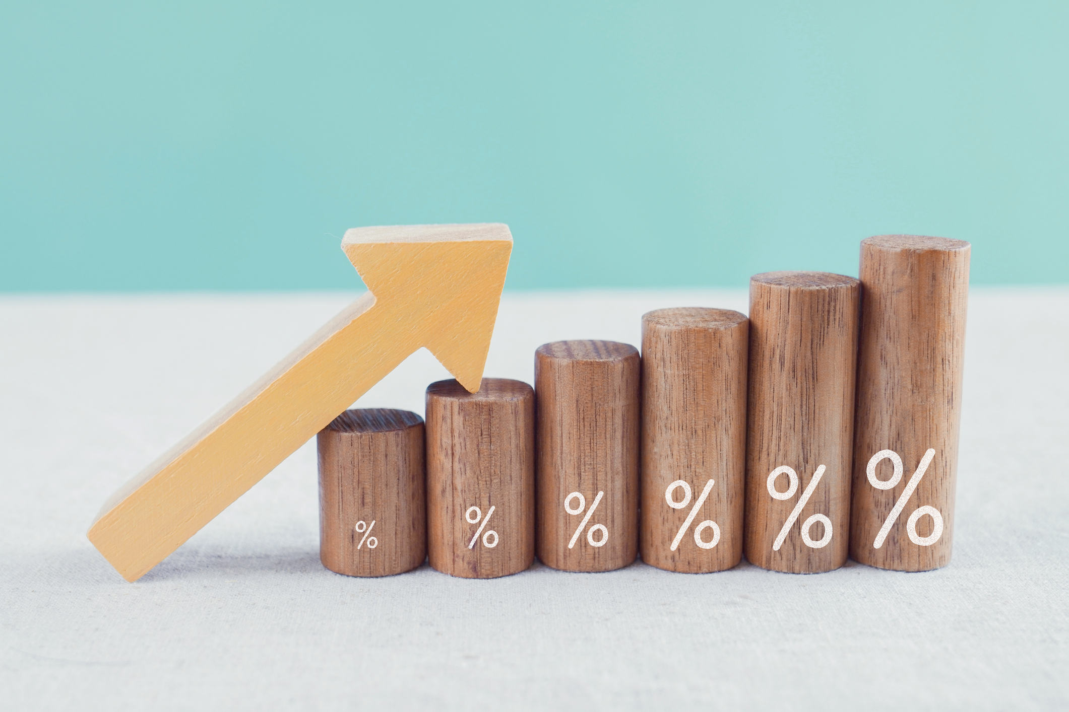 Arrow resting atop ascending wooden blocks with percentage signs also increasing in size written on them. Arrow resting atop ascending wooden blocks with percentage signs also increasing in size written on them.