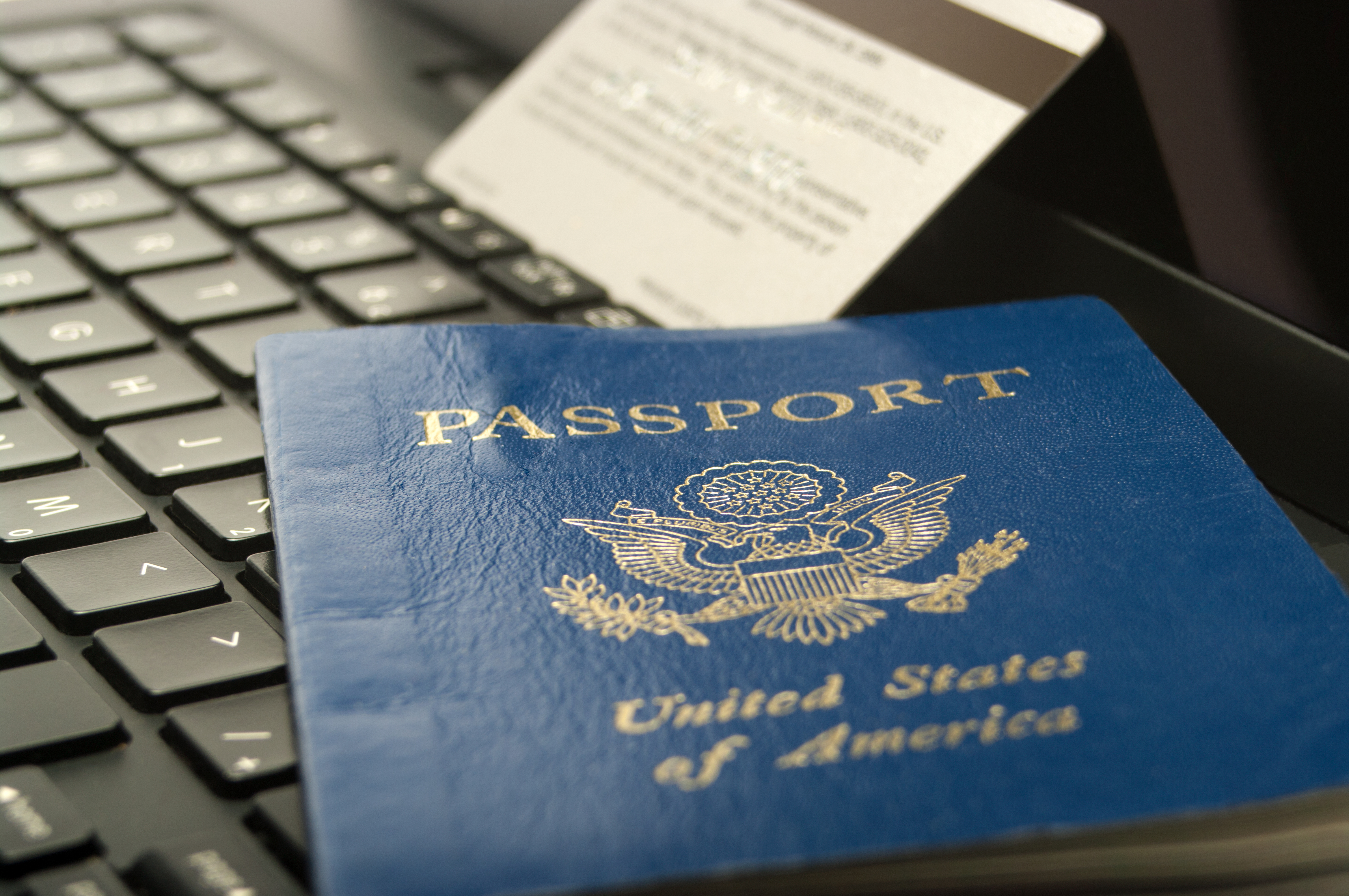 passport and credit card on a laptop