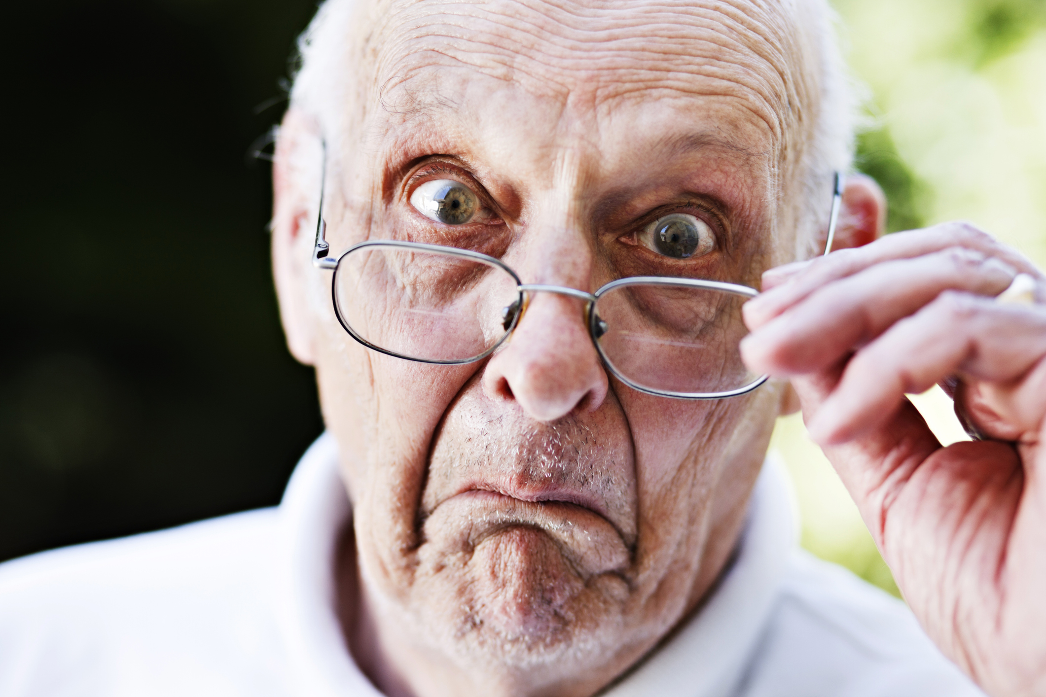 Getty - interested intrigued curious questioning amazing wow A close-up of a surprised person looking over their glasses.