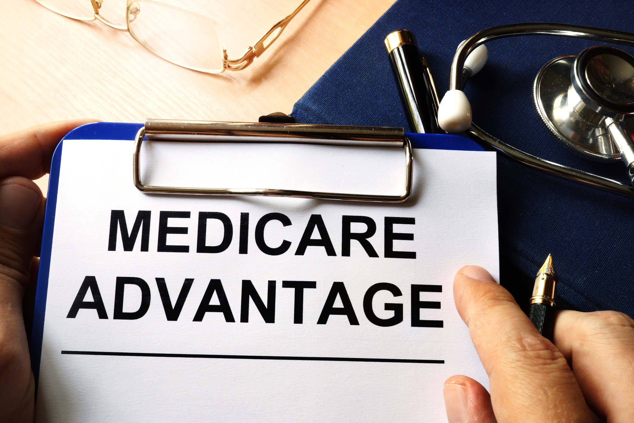 medicare advantage plan health care healthcare The words Medicare Advantage are printed on a paper clipped to a clipboard.