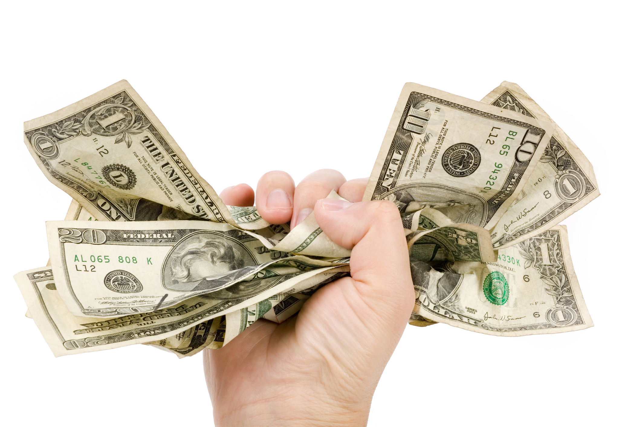 Gripping dollar bills in an iron fist A hand tightly gripping a bundle of dollar bills in various denominations.