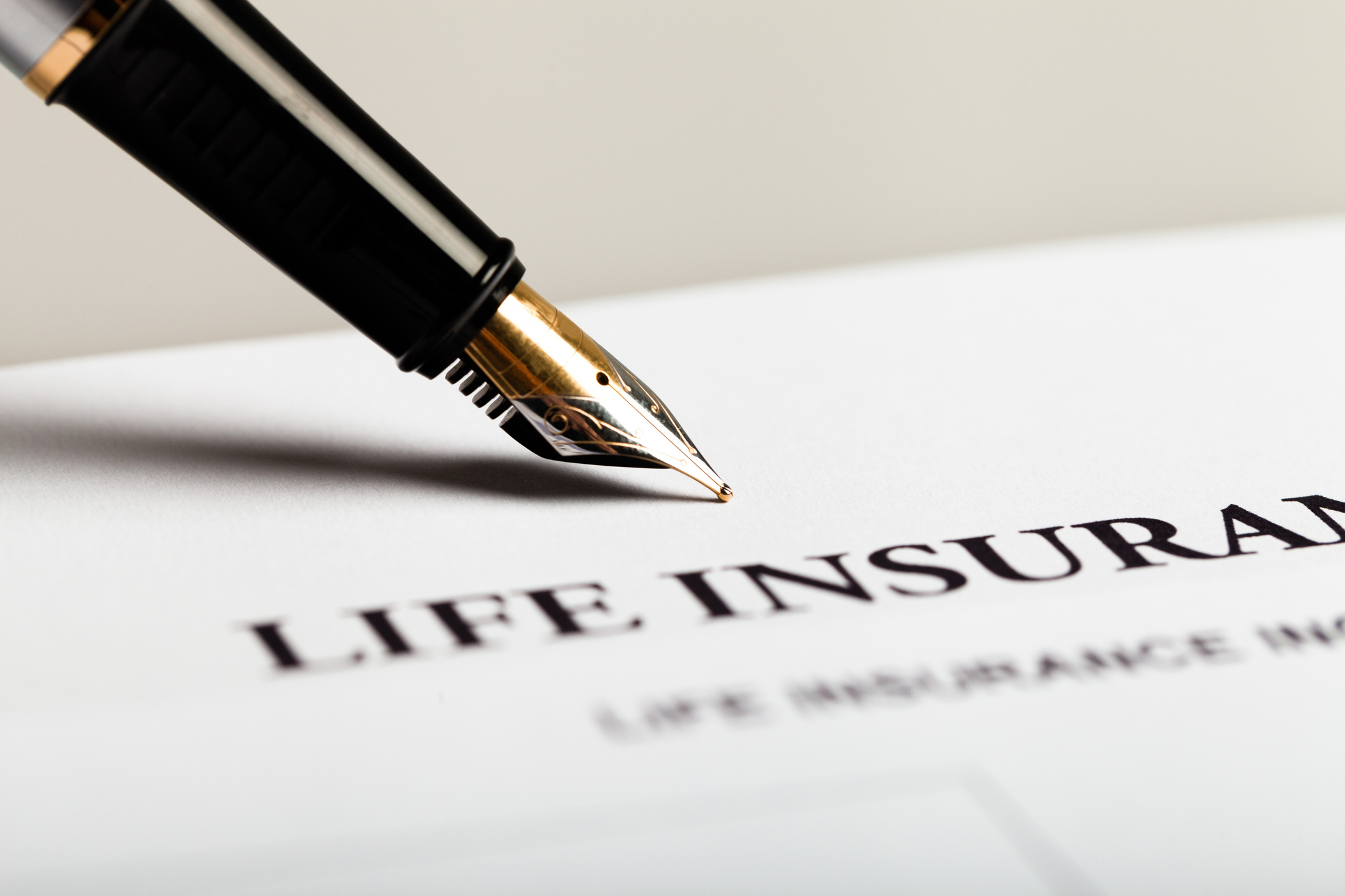 A life insurance document and ink pen A life insurance document and ink pen.