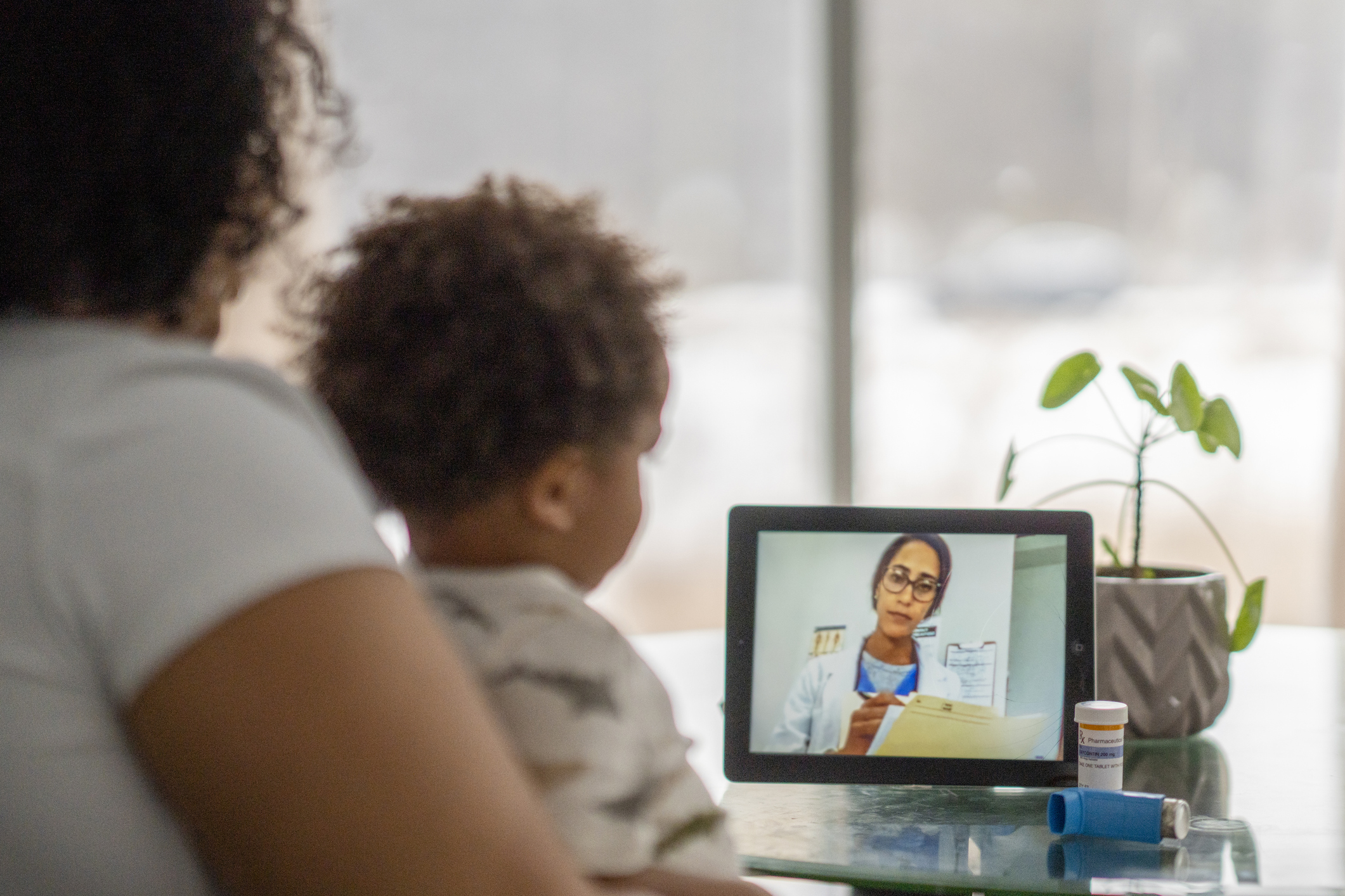 Mother and child on telehealth call with doctor Mother and child on telehealth call with doctor