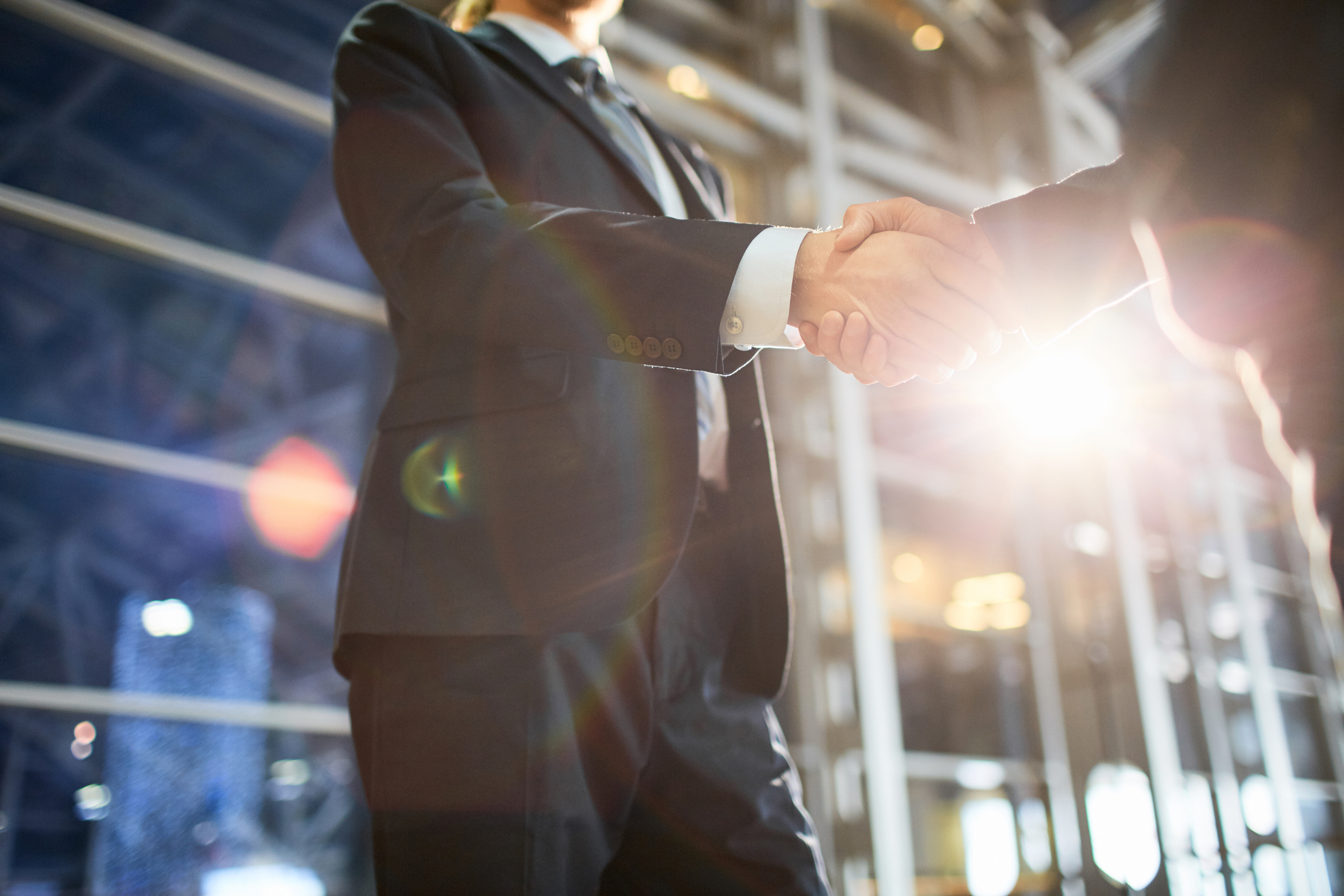 People shaking hands outside of a building. People shaking hands outside of a building.