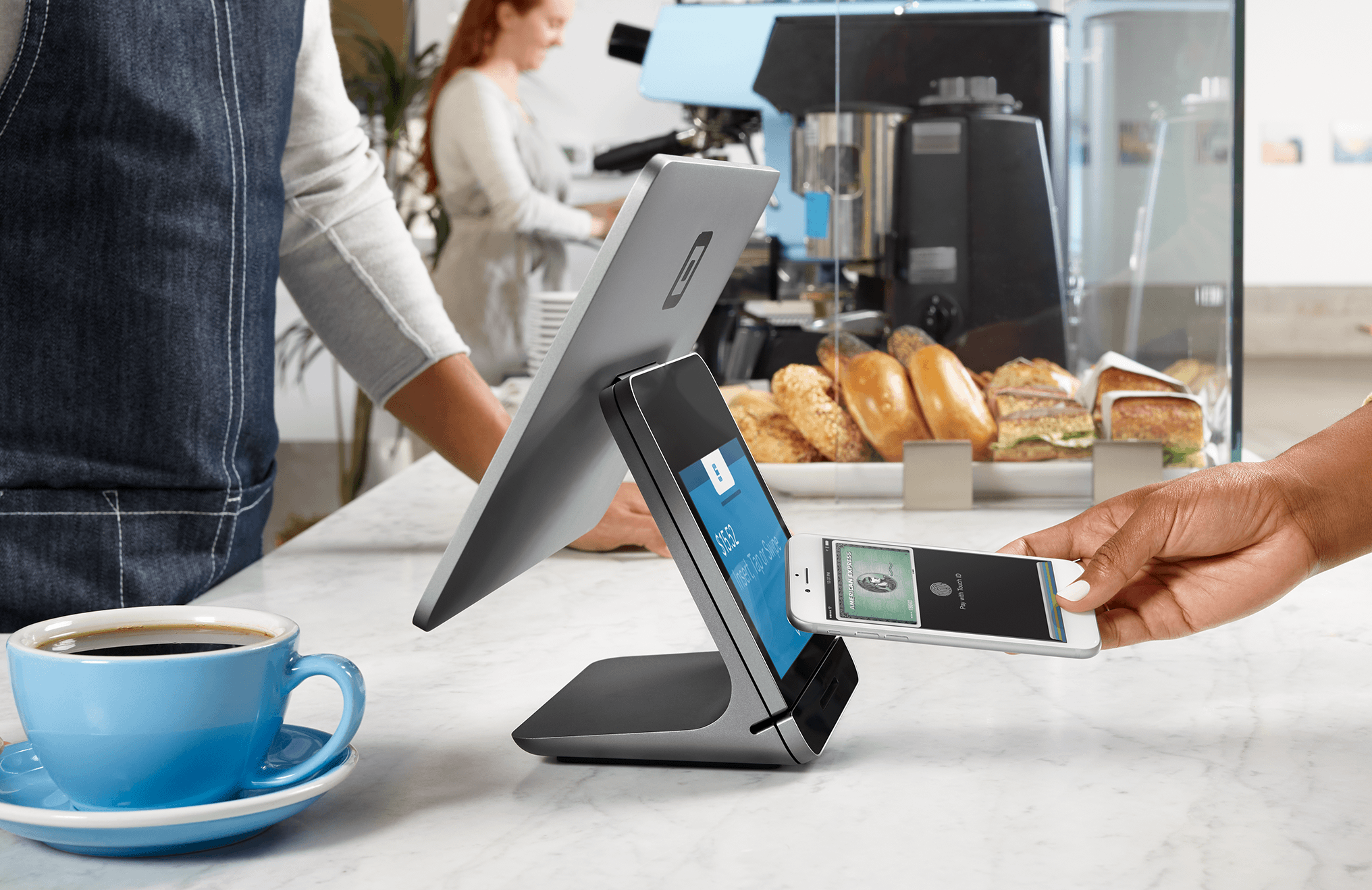 Person uses smartphone to pay at a Square register. Person uses smartphone to pay at a Square register.