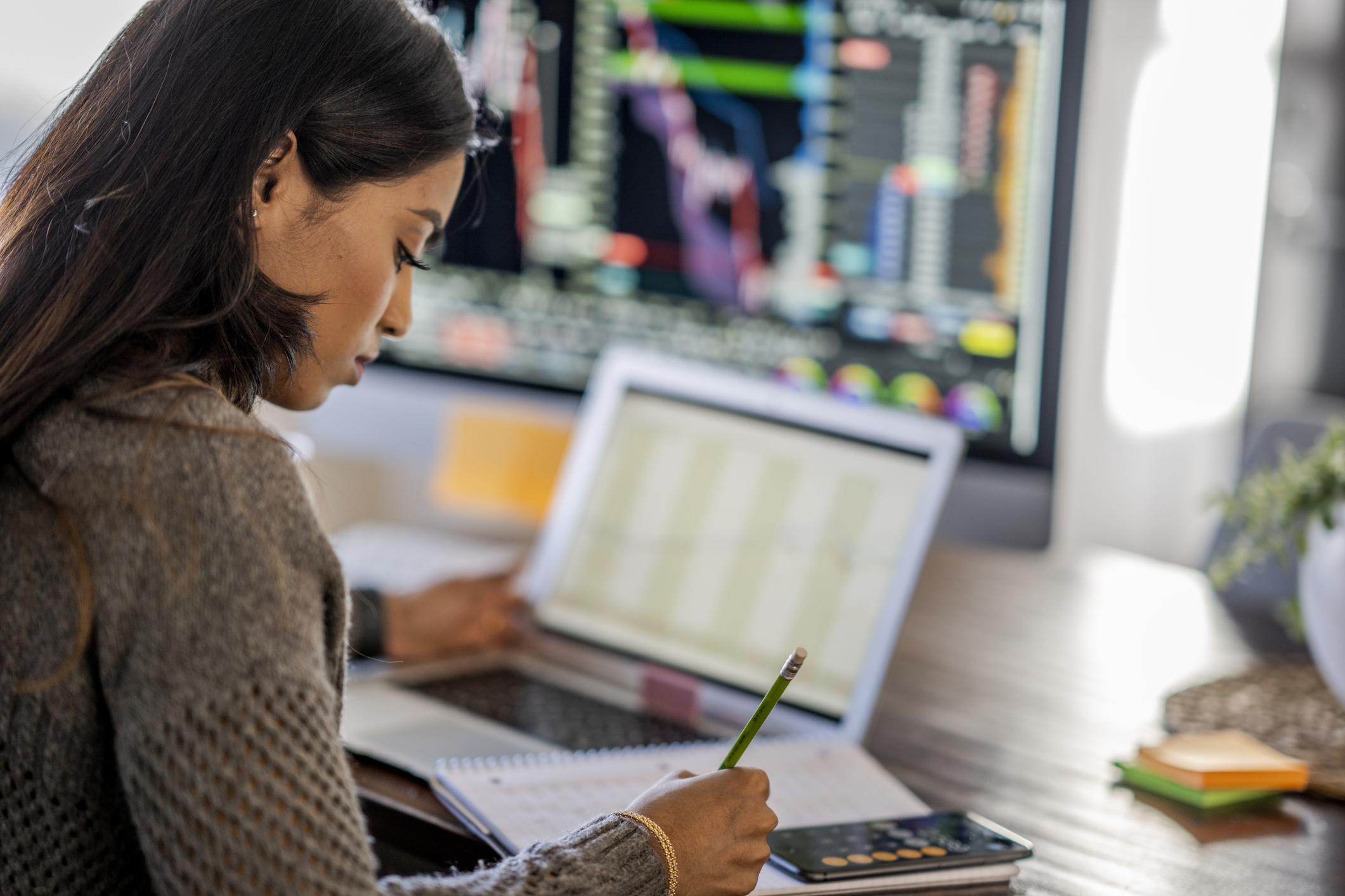 Person reviewing data on multiple computer monitors. Person reviewing data on multiple computer monitors.