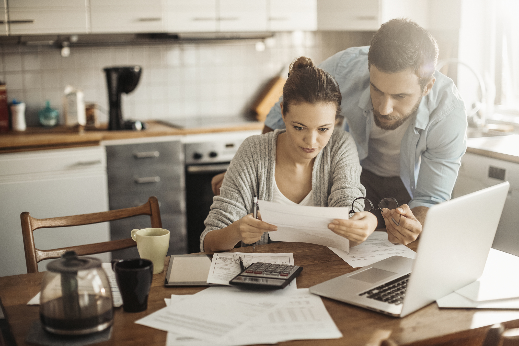 Two people in kitchen reviewing paperwork.