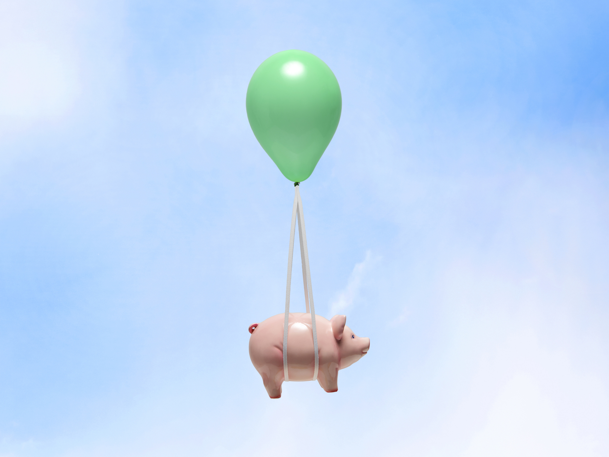 Piggy bank floating in the sky tethered to a green balloon Piggy bank floating in the sky tethered to a green balloon