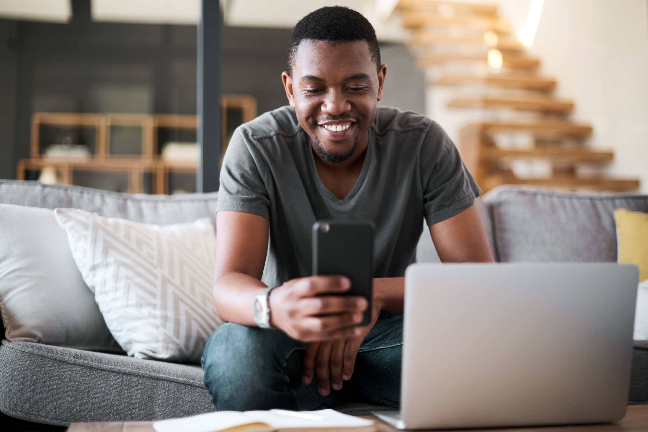 Young investor smiling looking at phone.