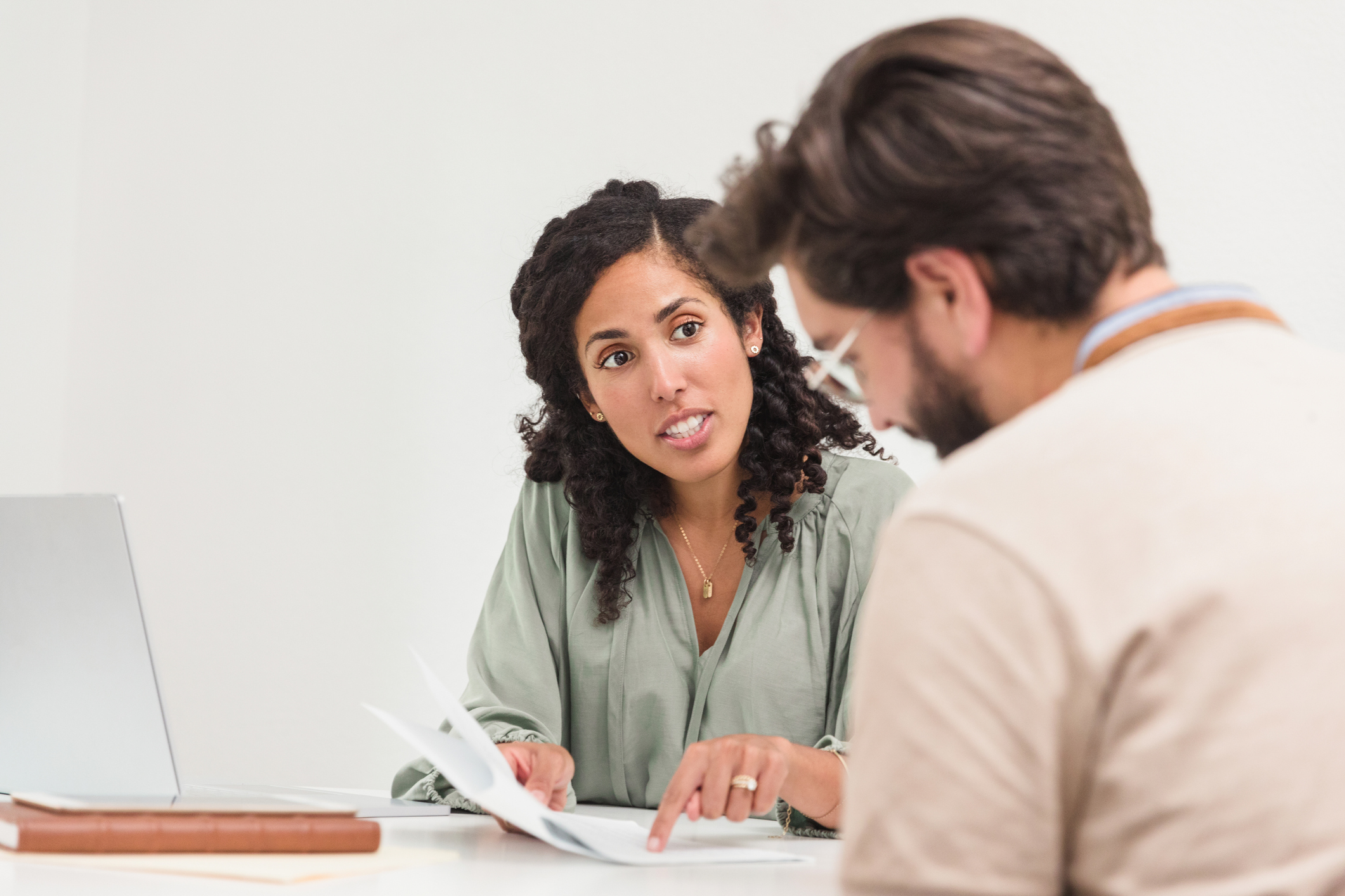Businessman and businesswoman sitting at table reviewing documents