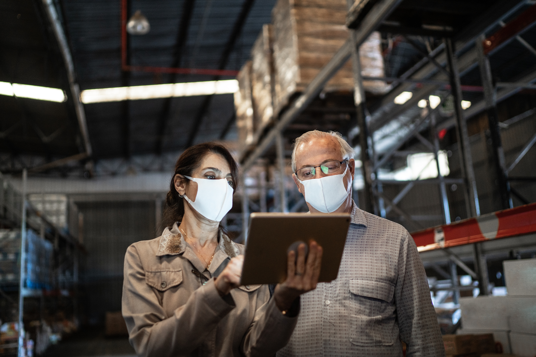 People checking inventory on tablet in storage warehouse