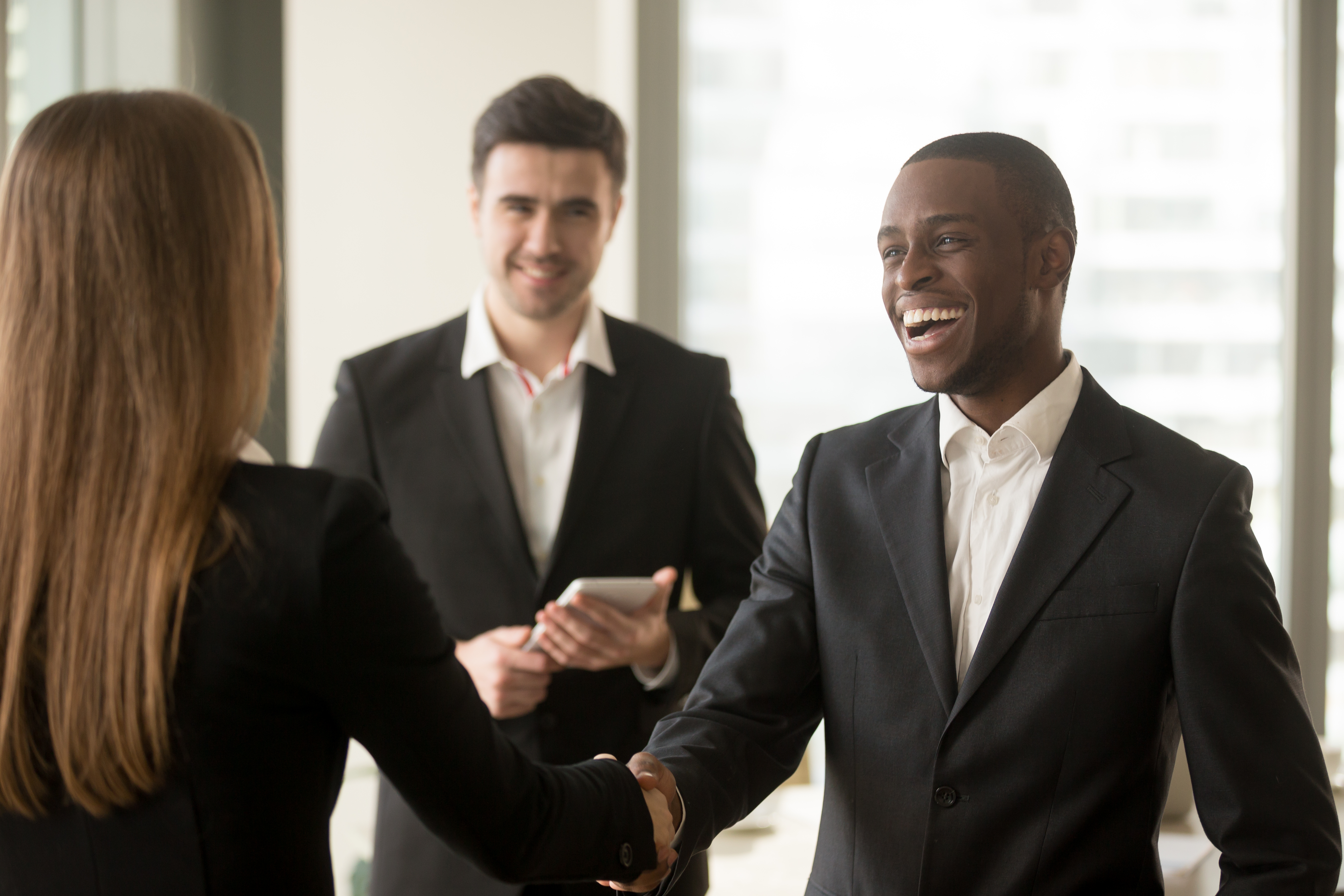 Smiling businesspeople sealing the deal with a handshake Smiling businesspeople sealing the deal with a handshake
