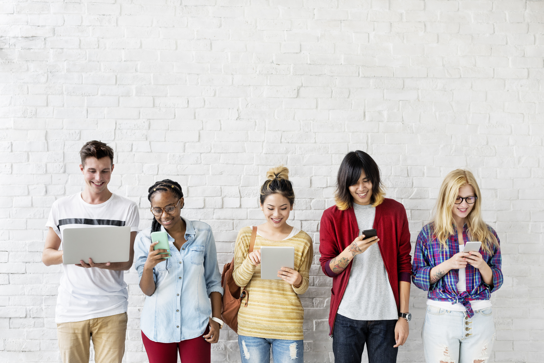 Young people on social media on laptop tablet smartphone A group of young people on social media on laptops, tablets, and smartphones