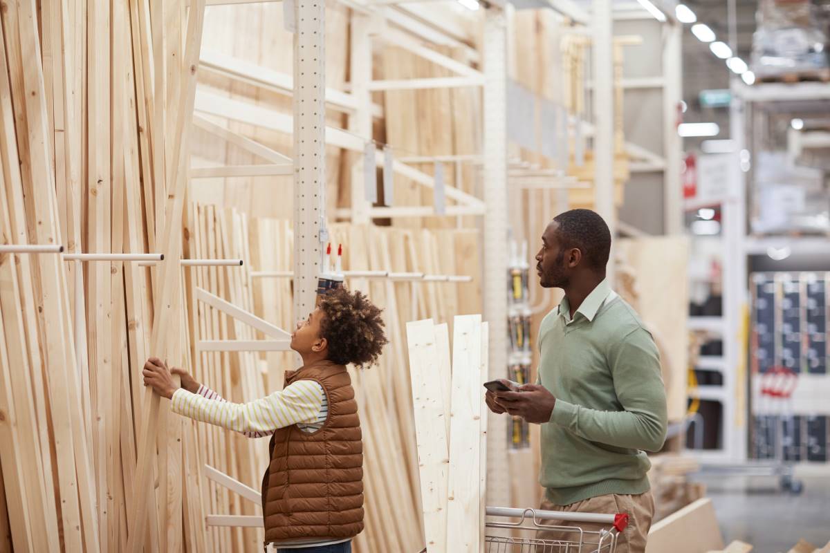 Wood_Lumber_Stocks_ETFs_Image_resized Adult and child looking at wood and lumber.