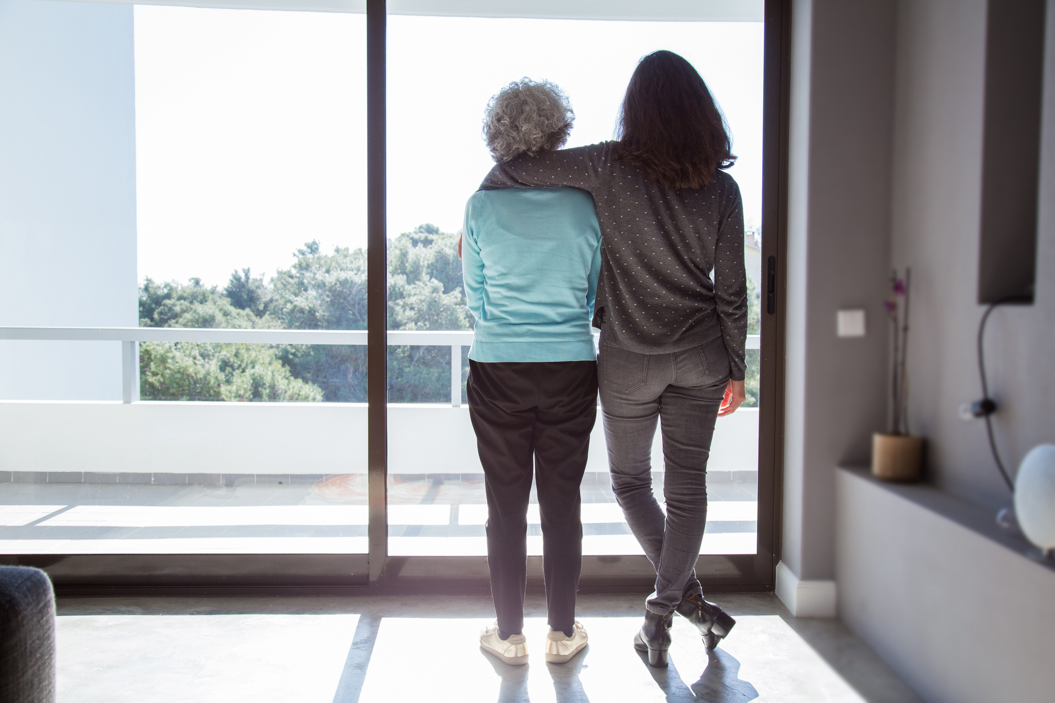Aging parent Young person with their arm around an older person.