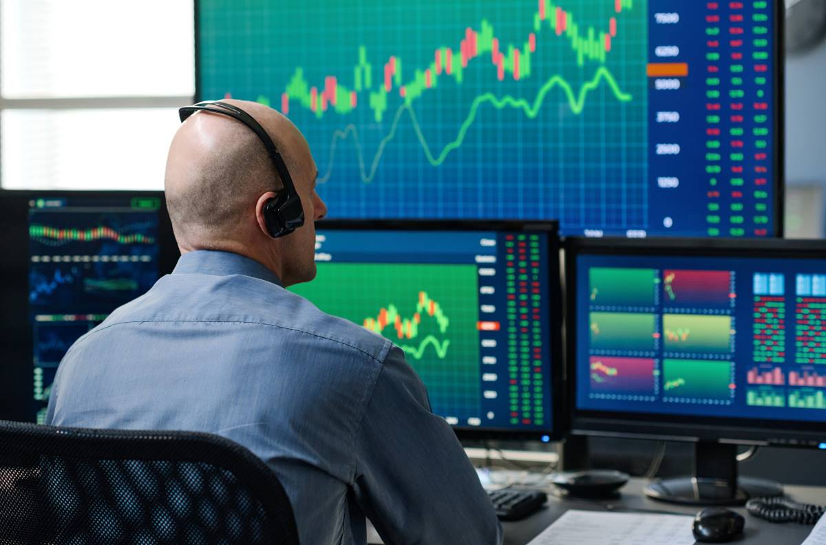 analyst viewing stocks investing tracking growth_1200x800 Person viewing charts on multiple monitors.