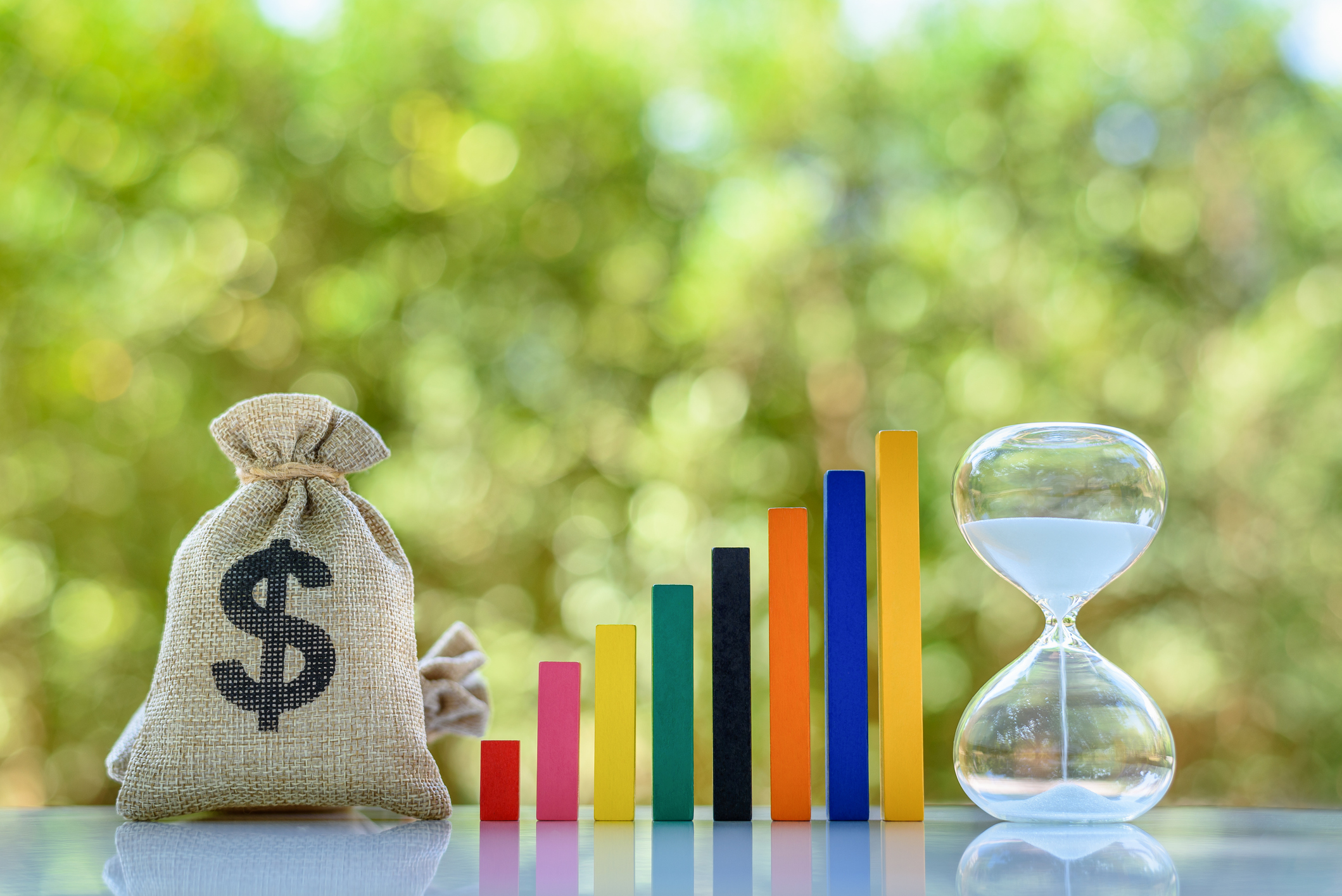 Bag of money and hourglass illustrate growing investment. Bag of money and hourglass illustrate growing investment.