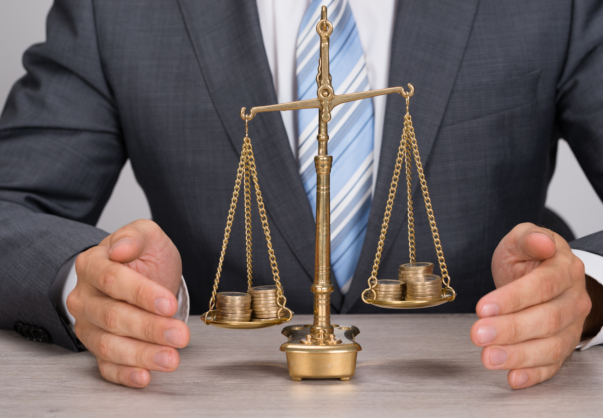 Businessman with scale weighing coins