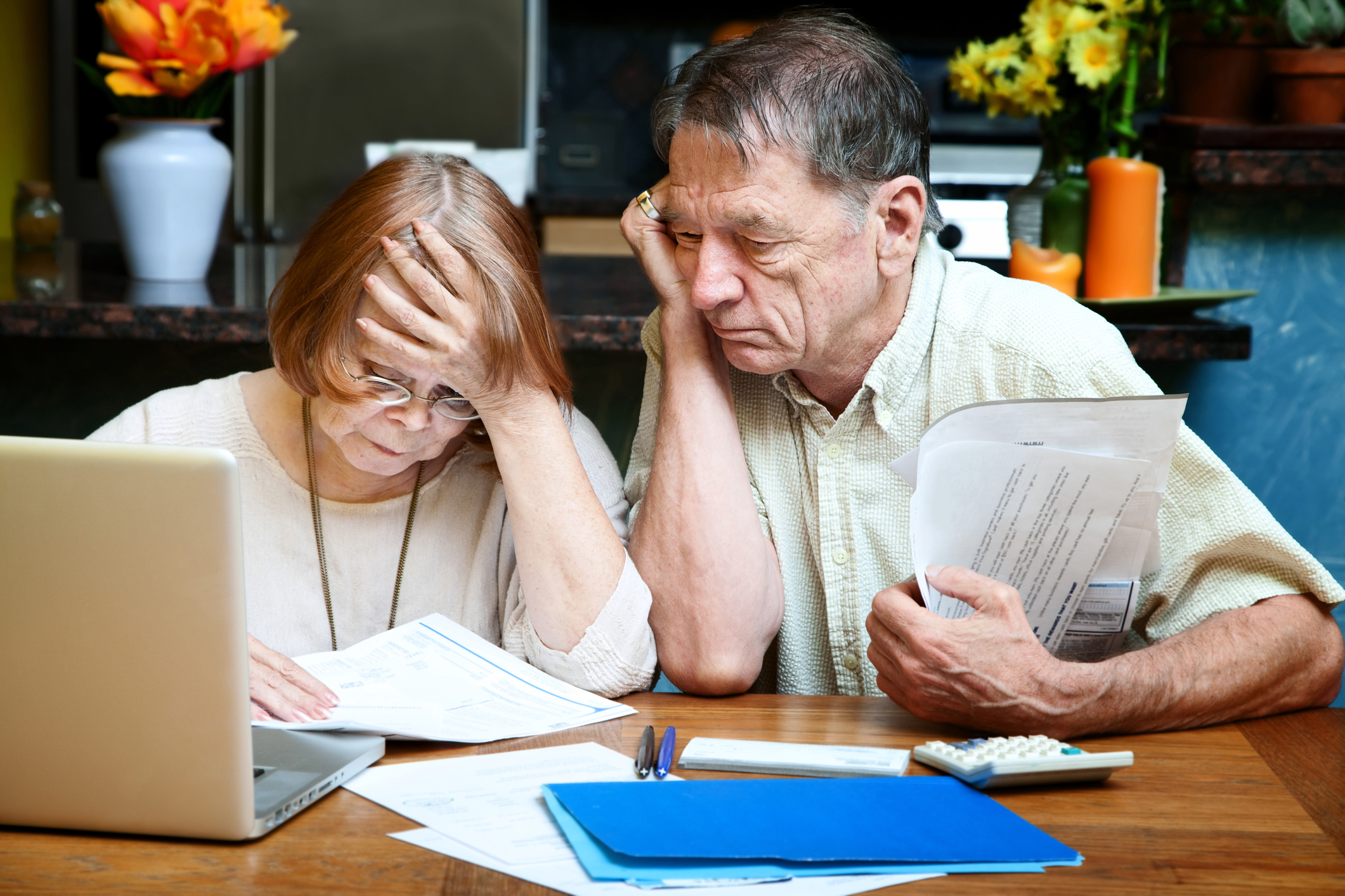 An elderly couple looking through paperwork together. An elderly couple looking through paperwork together.
