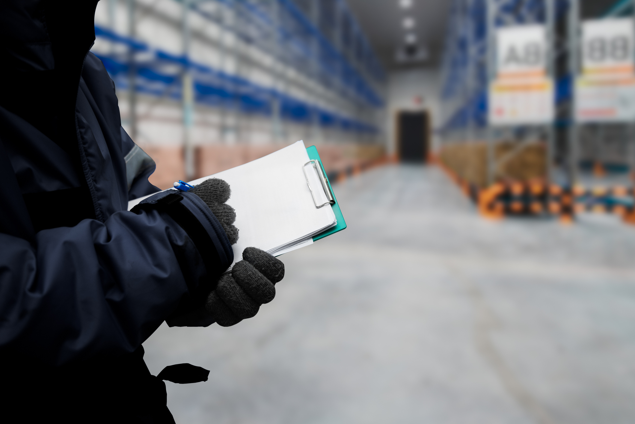 A gloved person working inside a cold-storage warehouse.