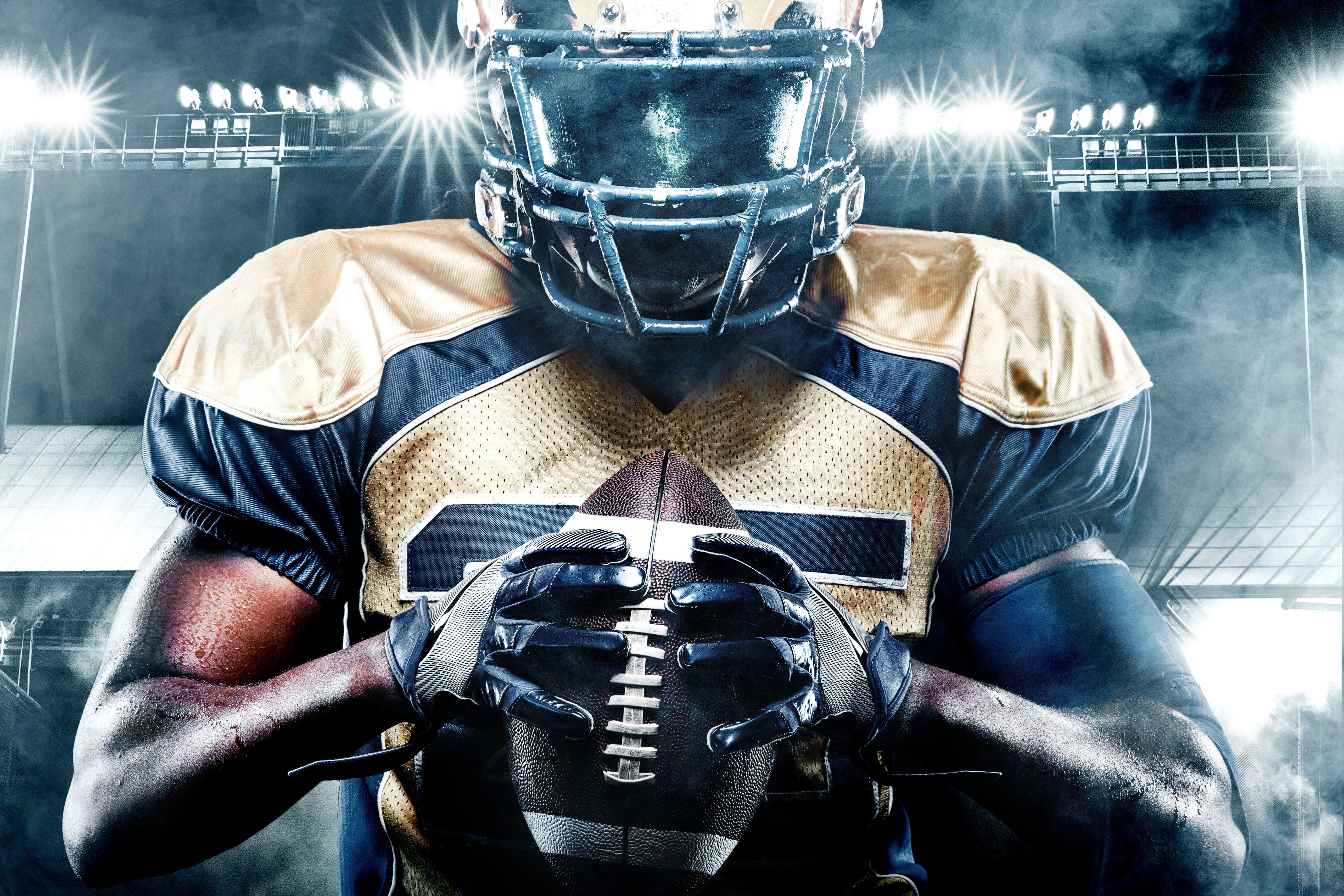 Football player holding a football. Football player holding a football.
