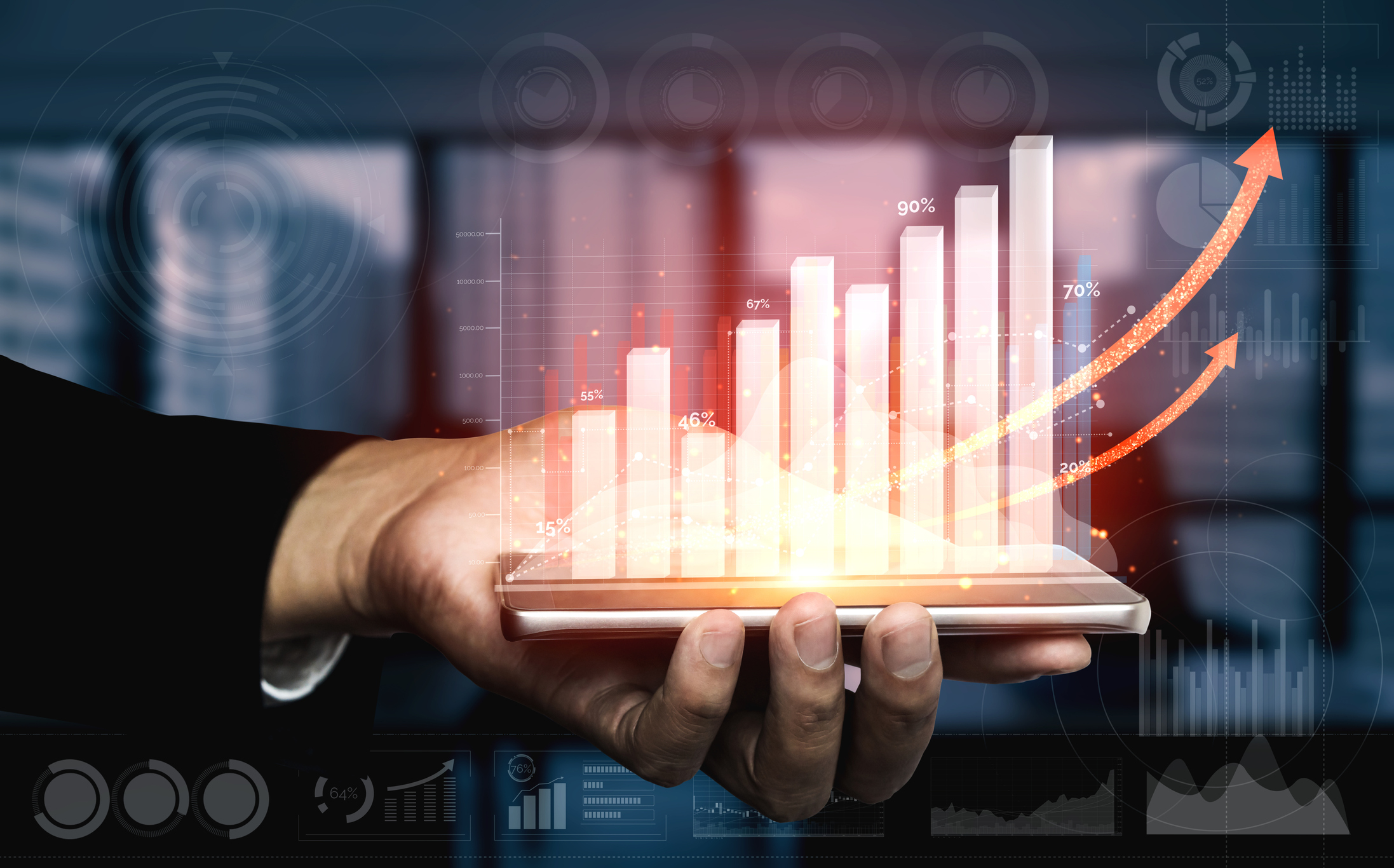 Hand holding financial markets indicator showing assets trending upward Hand holding financial markets indicator showing assets trending upward.