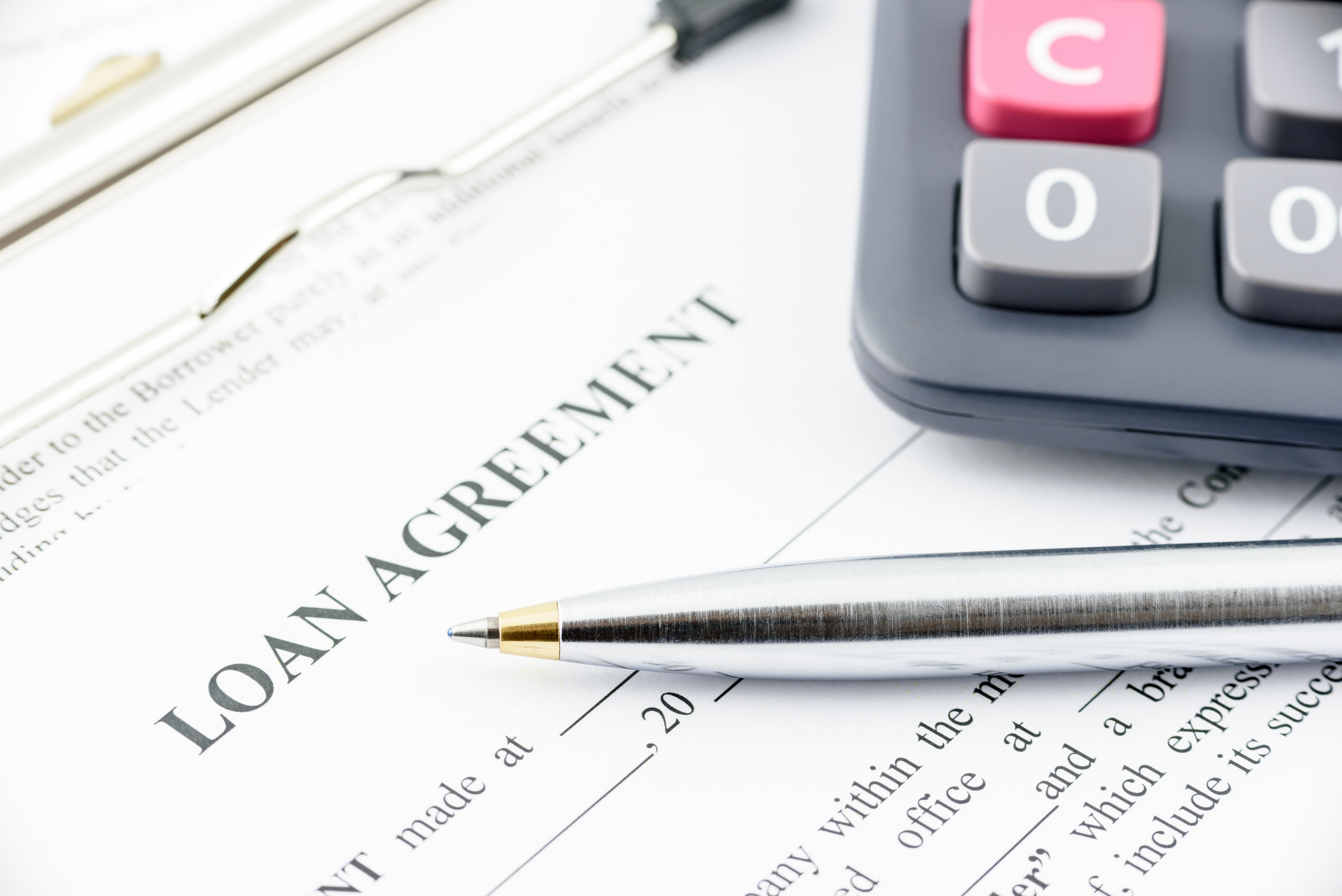 Loan agreement with pen and calculator Loan agreement with pen and calculator.
