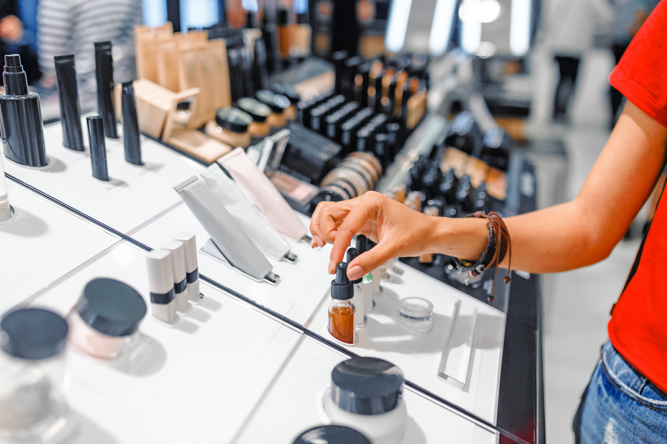 Person browsing cosmetics section at store Person browsing cosmetics section at a department store.