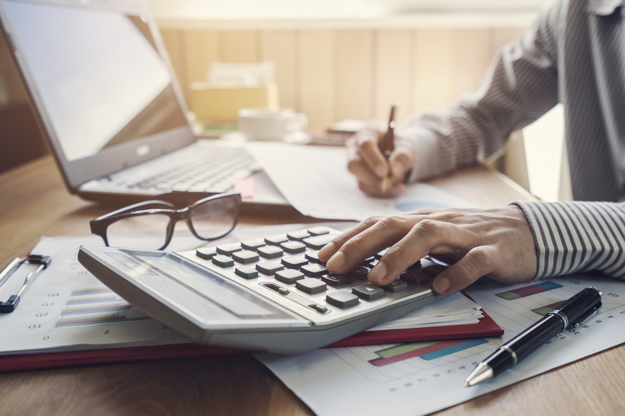 Man taking notes and using a calculator