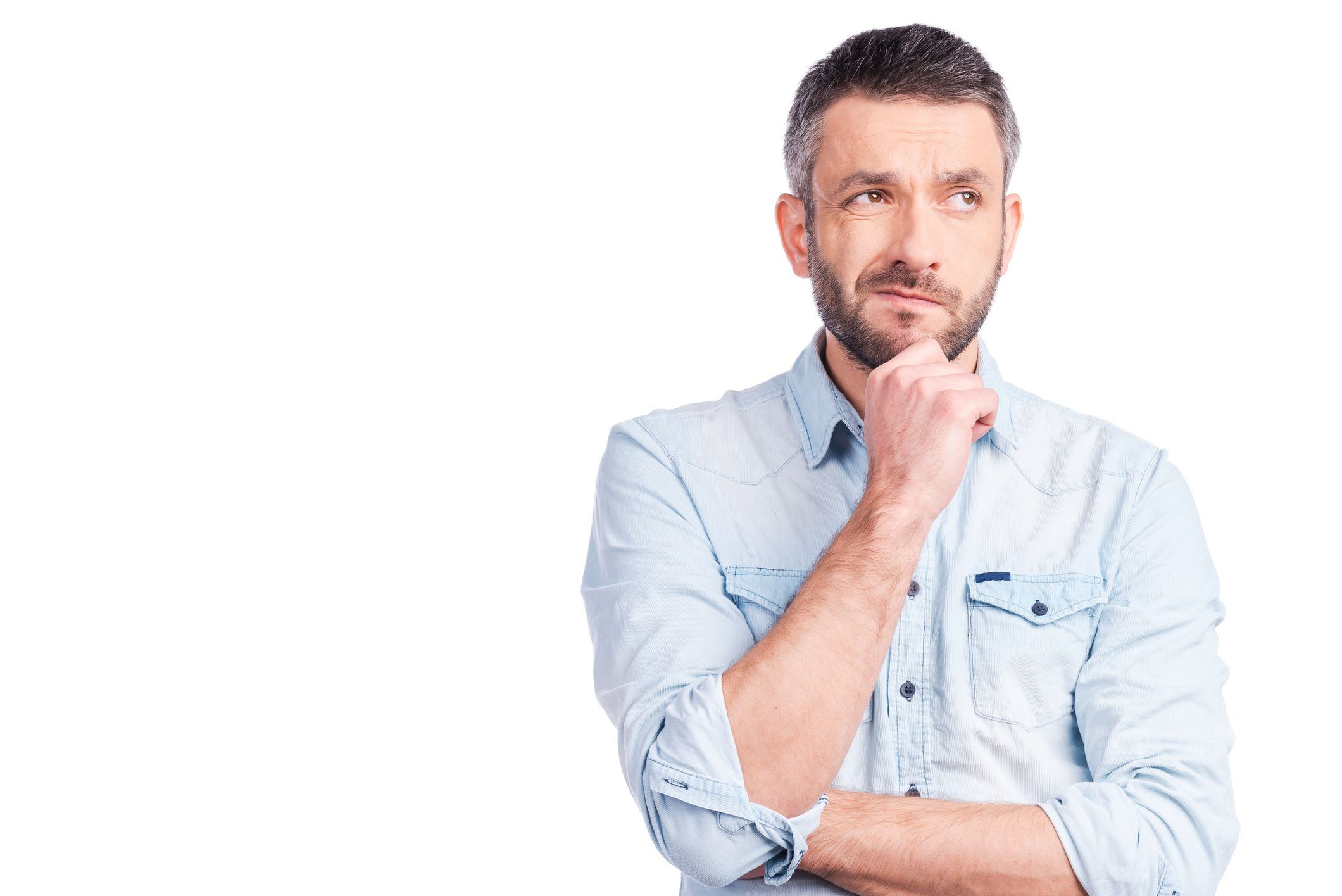 Mature man thinking with hand to his chin.