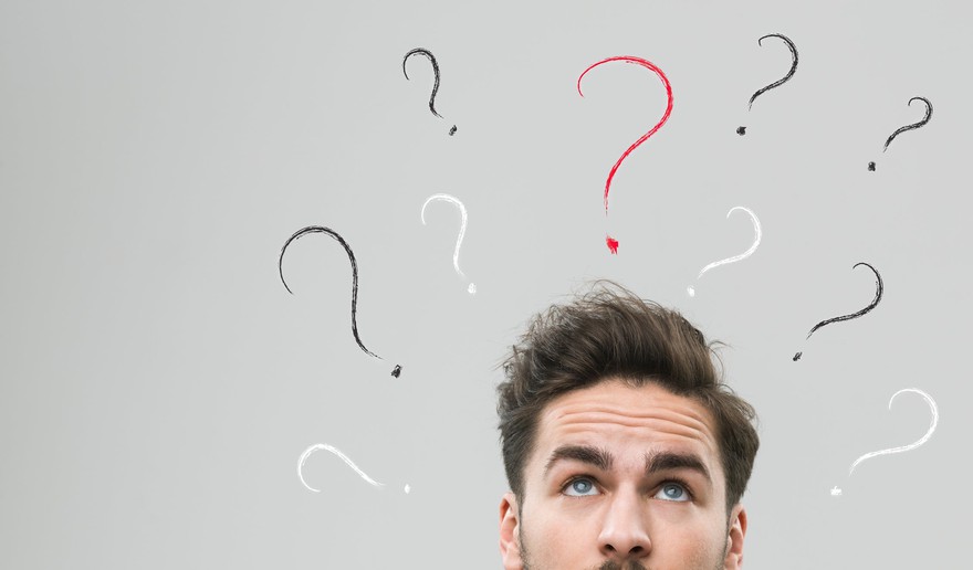 Man looks up to question marks floating above his head. Man looks up to question marks floating above his head.