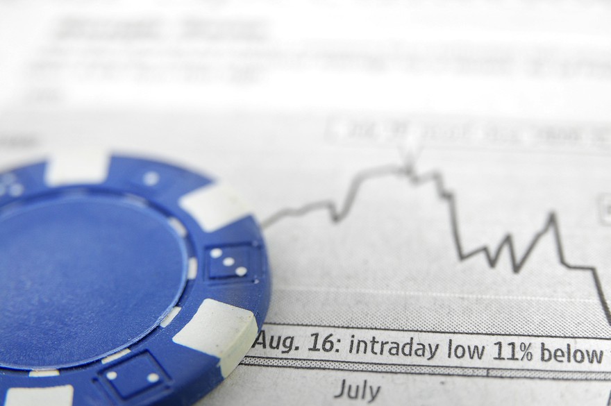 A blue poker chip atop a graph. A blue poker chip atop a graph.