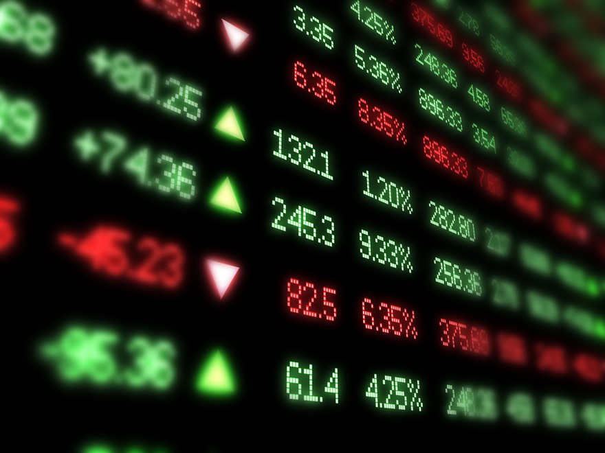 A digital board displaying stock prices in green and red. A digital board displaying stock prices in green and red.
