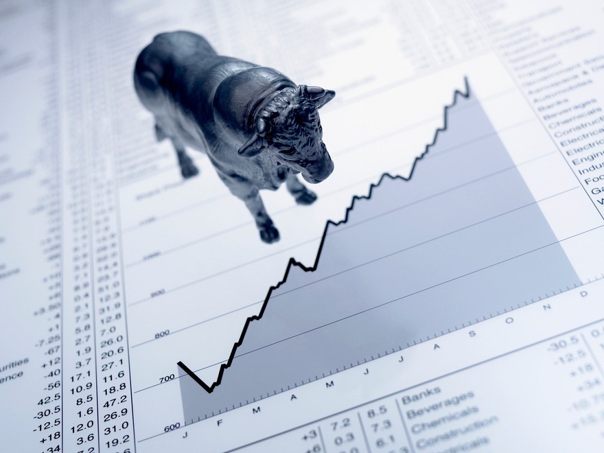 bull figurine next to positive trending graph bull figurine next to positive trending graph