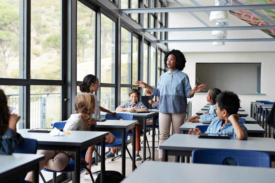 A teacher speaking to a group of children. A teacher speaking to a group of children.