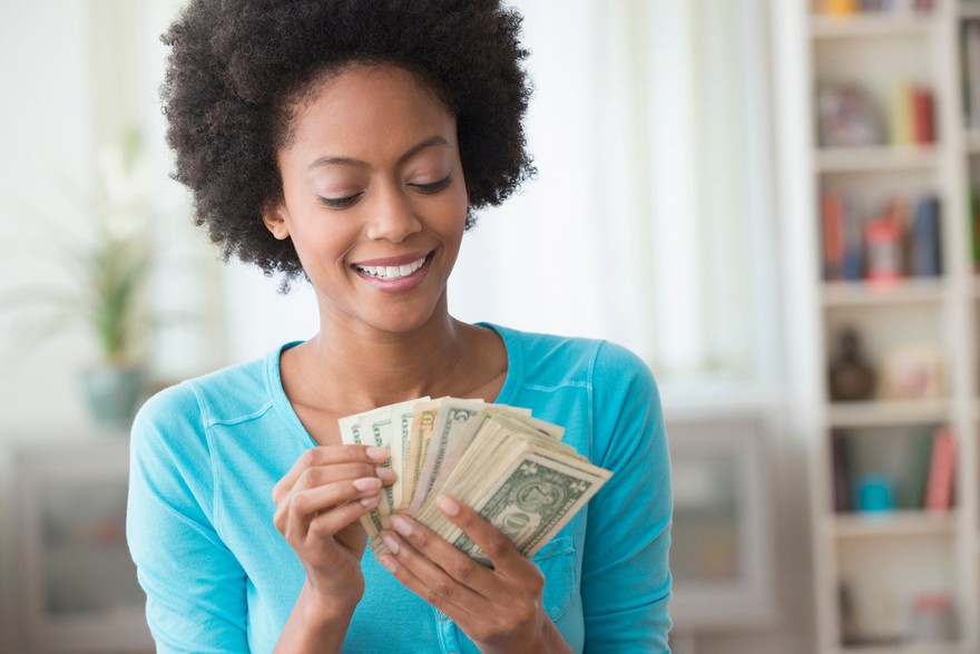 Smiling woman holding cash in her hands Smiling woman holding cash in her hands