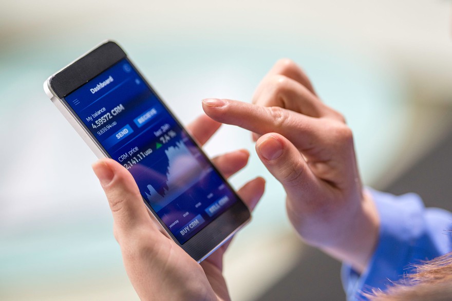 A person submitting a stock order on a mobile device. A person summitting a stock order on a mobile device.
