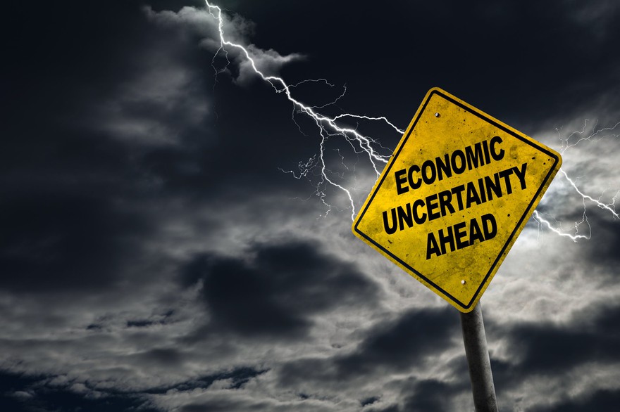 Economic Uncertainty sign against a stormy background with lightning. Economic Uncertainty sign against a stormy background with lightning.