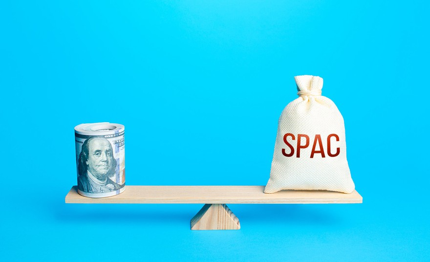 Bundle of dollars and a bag of SPAC on scales. Bundle of dollars and a bag that says SPAC on a seesaw balance..