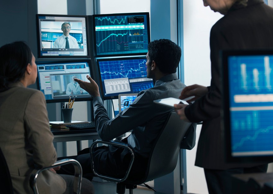 People looking at stock market screens. People looking at stock market screens.