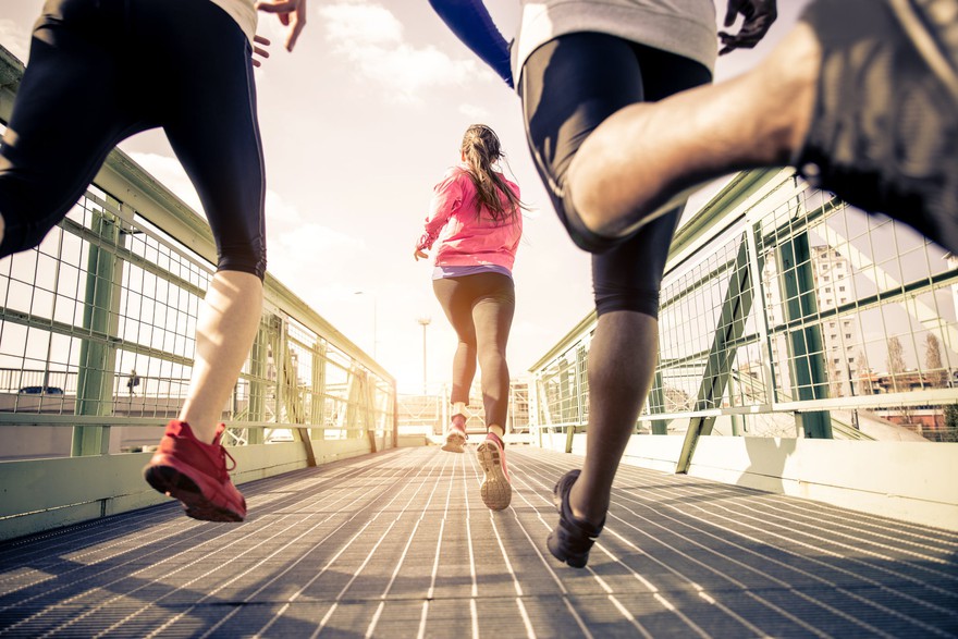 Three people in sportswear and shoes running across a bridge. Three people in sportswear and shoes running across a bridge.