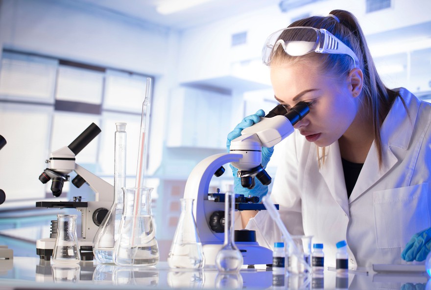 A scientist looking through a microscope. A scientist looking through a microscope.