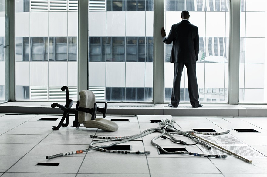A man gazing out the window after the company goes bankrupt.