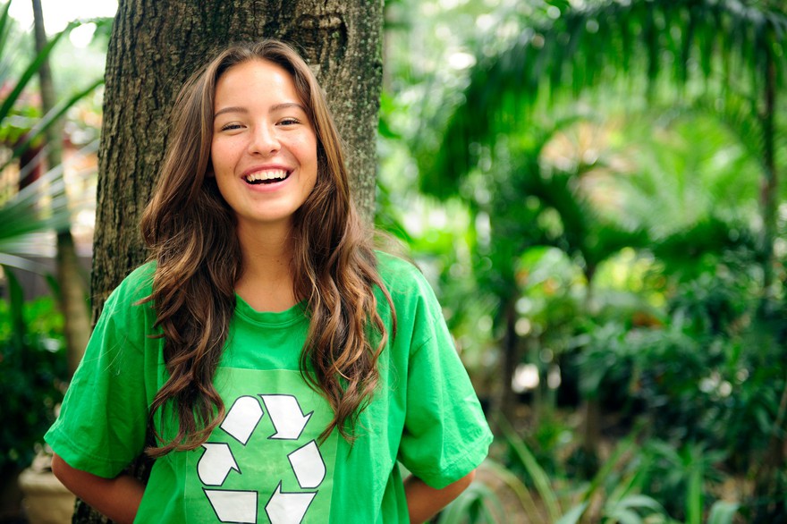 Young adult smiling, wearing a recycle t-shirt. Young adult smiling and wearing a t-shirt with the recycle logo on it.