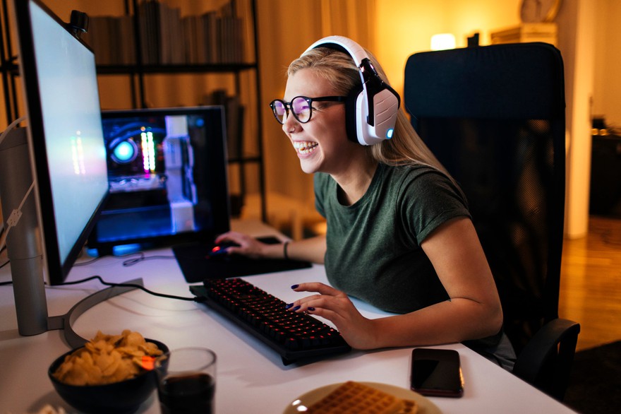 Premium Photo  Player feeling happy after winning video games on computer.  man celebrating online win and playing games with headphones and monitor.  gamer using gaming technology and equipment.