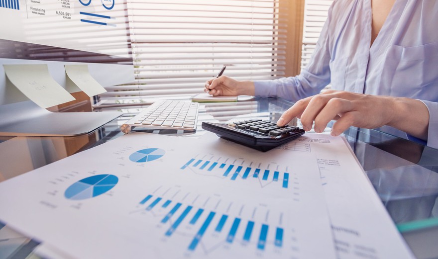 A business person calculating profit from revenue. A business person calculating profit from revenue.