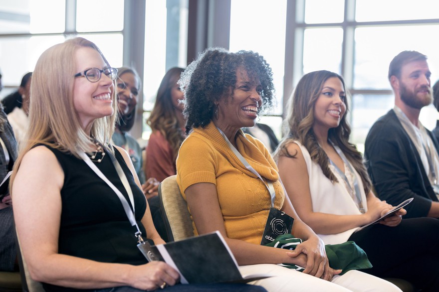 People smiling at a conference. People smiling at a conference.