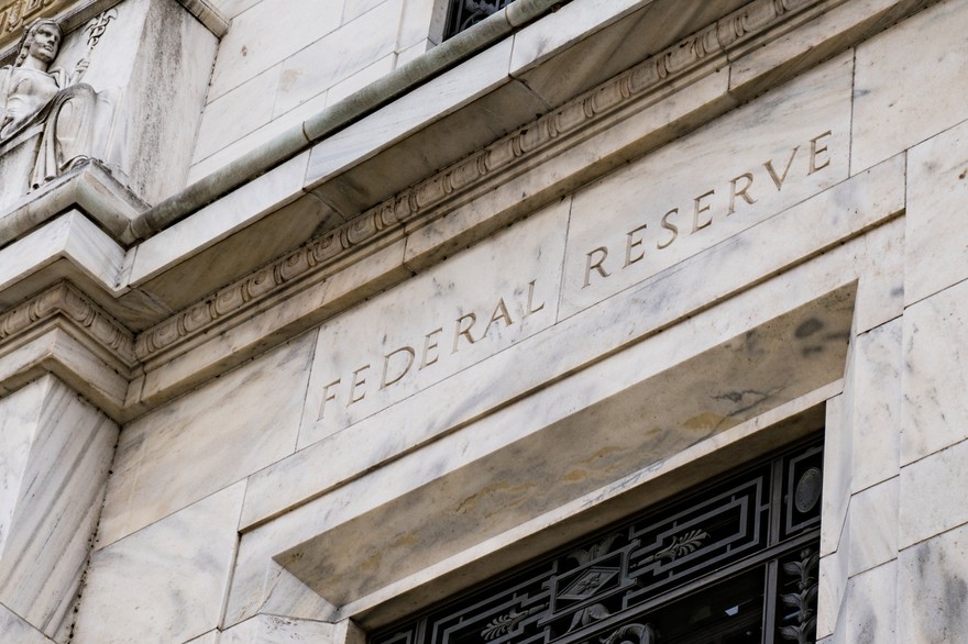 Entrance of a stone building with Federal Reserve carved above the door. Entrance of a stone building with Federal Reserve carved above the door.
